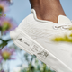 A close up of the Futurecraft.Footprint on a woman's foot as she jaunts through a field